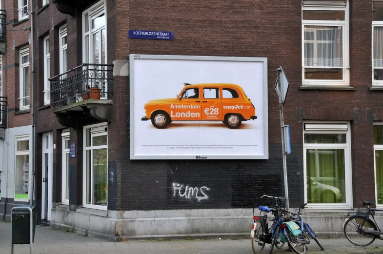 a van is advertising orange cars on a wall