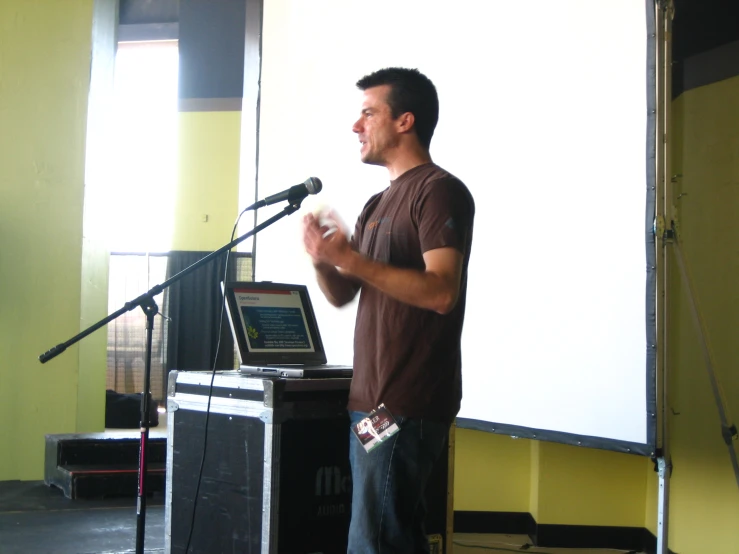 a man stands in front of a microphone with an open box on top of the podium