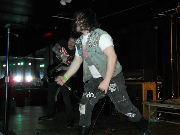 a person standing with a guitar on stage