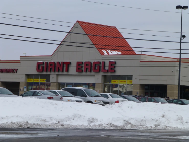 a store in a parking lot is covered in snow