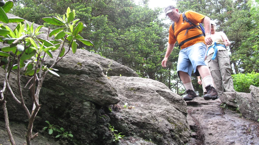a man hiking up a rock covered slope