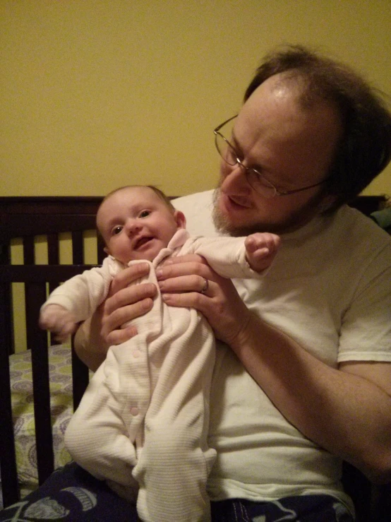 a man holding up a baby in his arms