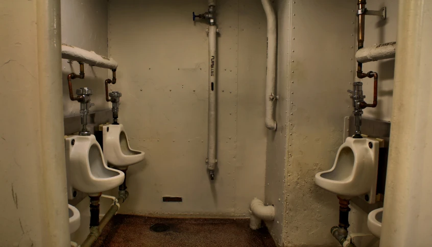 three urinals line the wall inside a men's bathroom