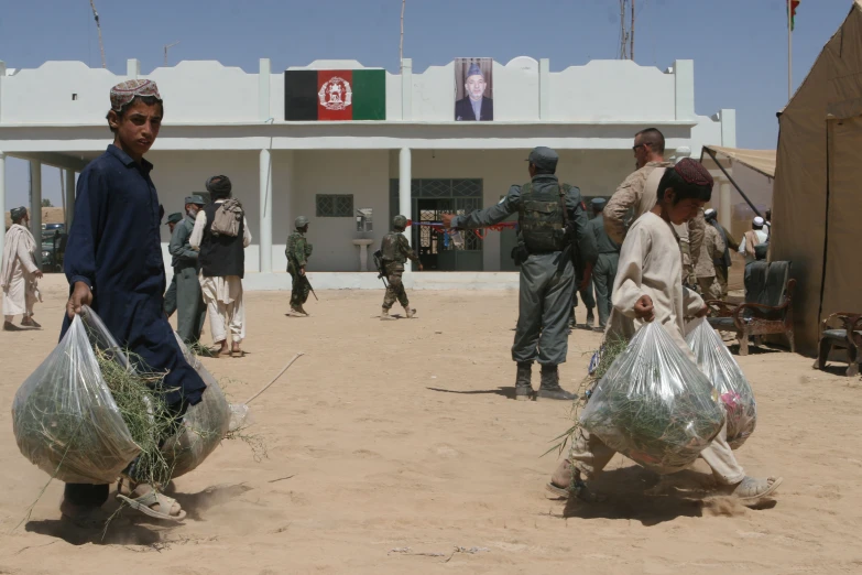 a man with two bags walking behind some other men