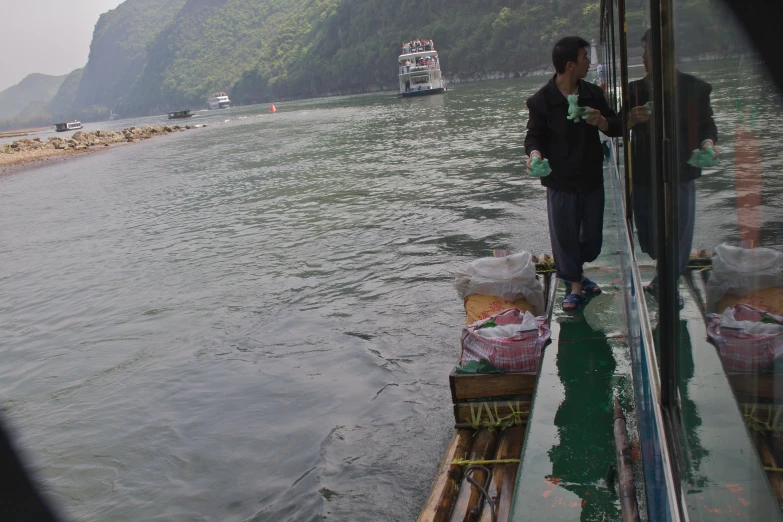 a boat on the water with a man in front of the dock