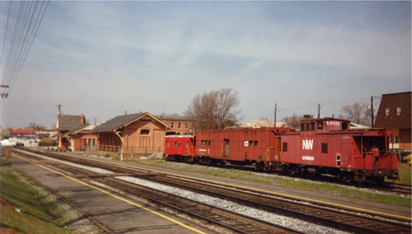 train tracks with a train on one side and a building with other side