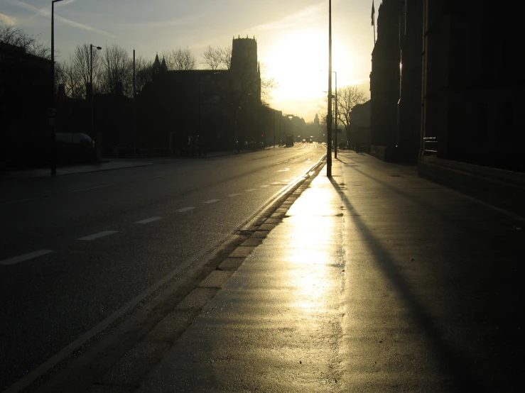 the sunlight shines brightly down the street behind a lamp post