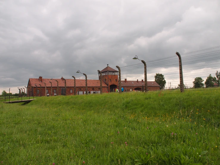 a brown house sitting on top of a lush green field