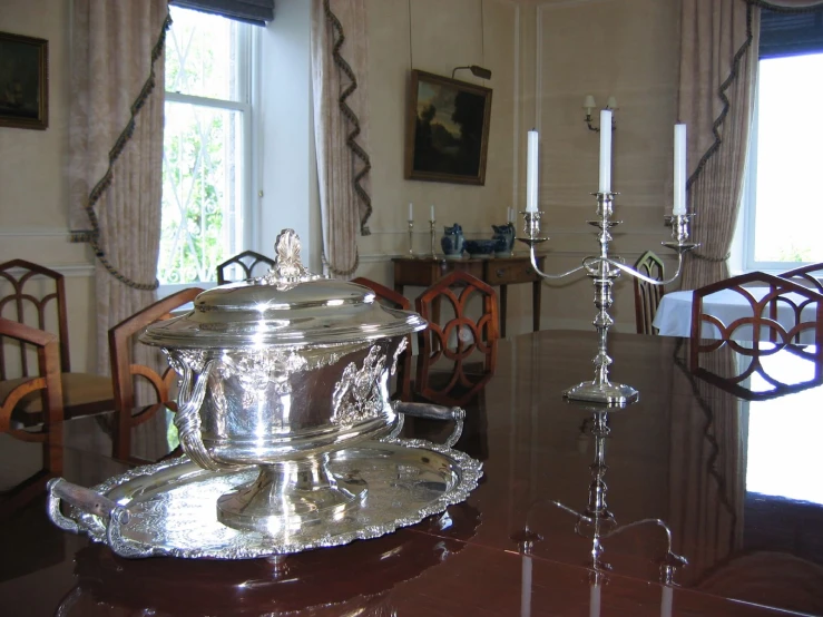 a silver plate on a glass table in the middle of a room
