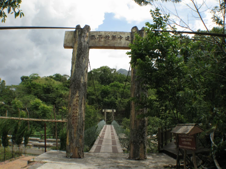 a bridge going across a river with trees in the background