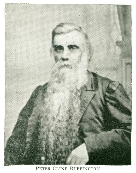 a man in a suit and hat sits next to a wall