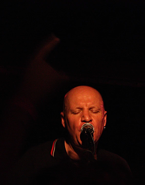 a man with his eyes closed, with his eyes closed in to the microphone