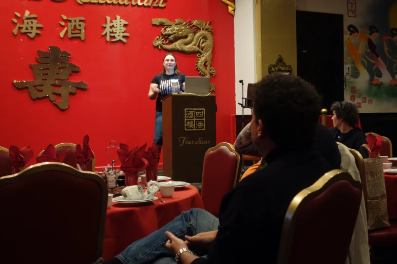 a person in a red room with a woman talking