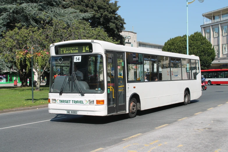 the city bus is driving down the road with no passengers