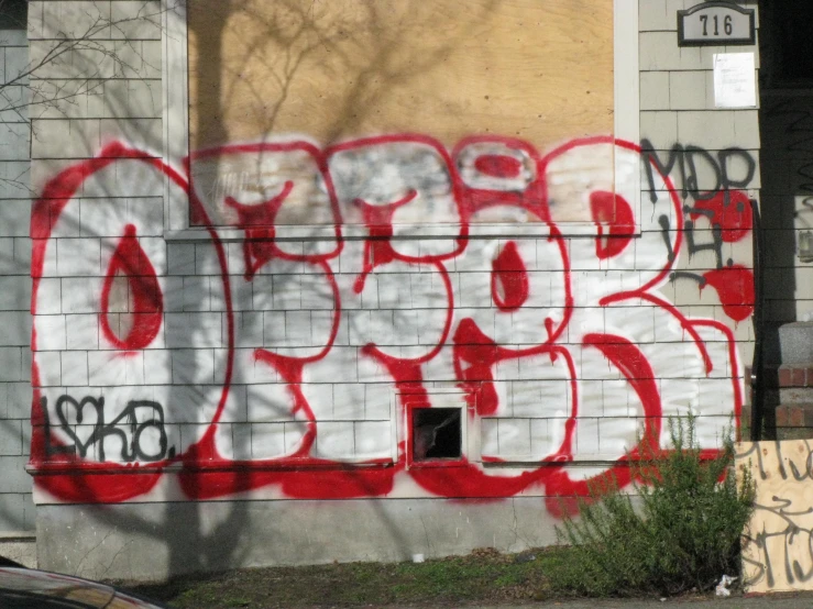 a large white and red graffiti on the side of a building