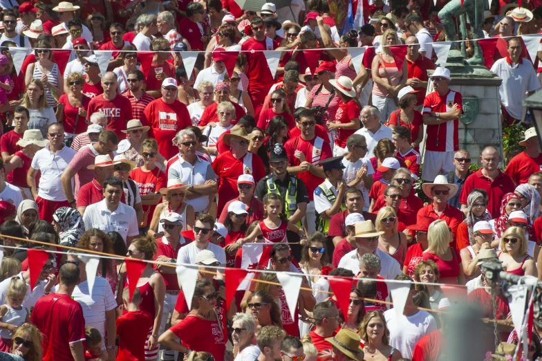 a large crowd is wearing red and white clothes