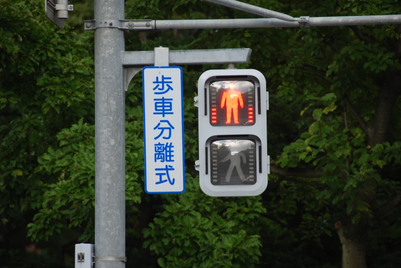 an asian street light is lit up by an english language sign