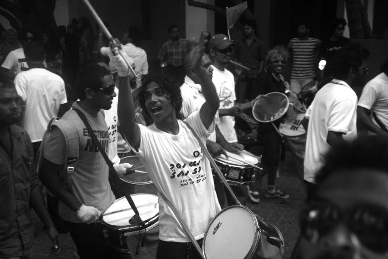 a black and white po of a drummer surrounded by other people