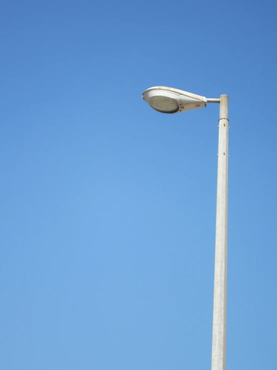 a stop light sitting underneath a street lamp