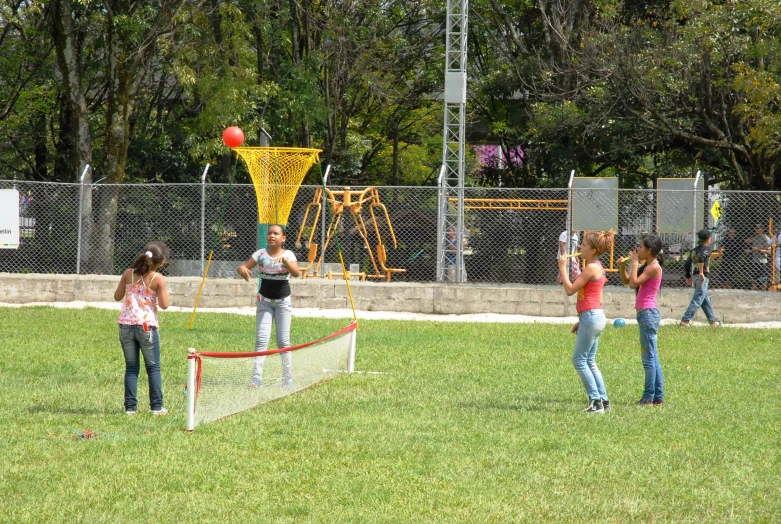 some s standing in a yard and playing with a ball