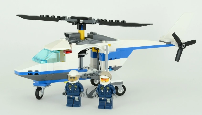 two lego police men stand near an airplane