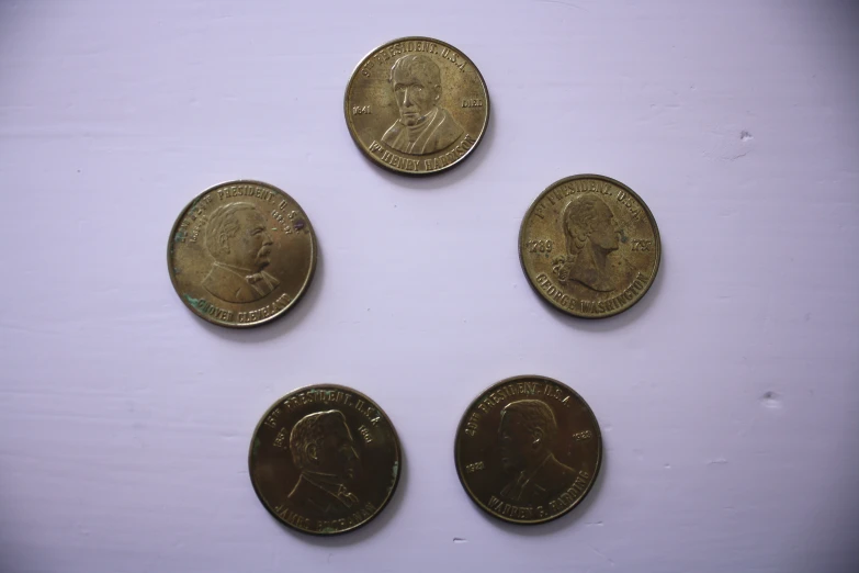 a row of five different gold coins sitting on top of each other