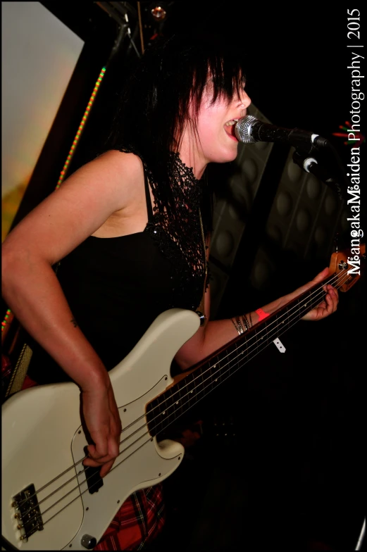 a woman with a black top is playing the bass