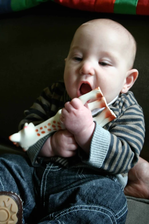 an infant in  jacket holding a banana