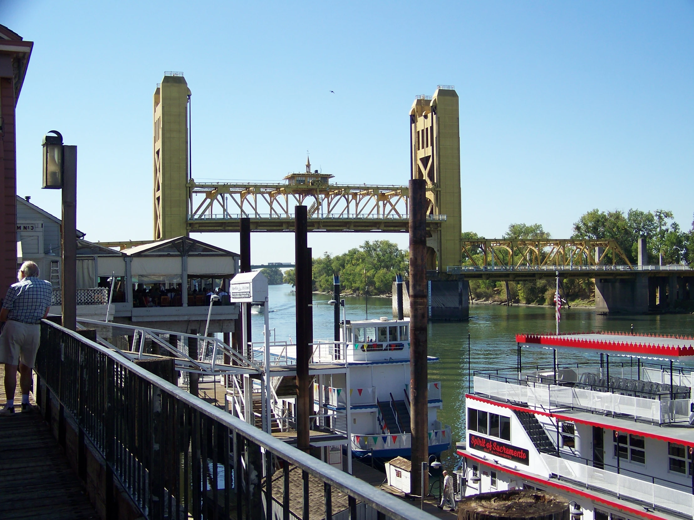 a boat sitting on top of a river under an overpass