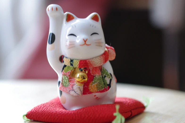 a cat statue sitting on top of a piece of cloth