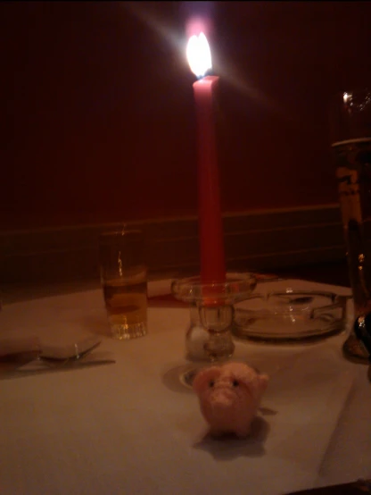 a stuffed bear sitting next to a lit candle