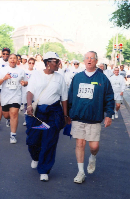 group of people running in a marathon, some with a white cap