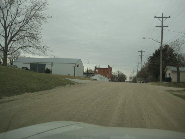 a dusty road near a farm and buildings