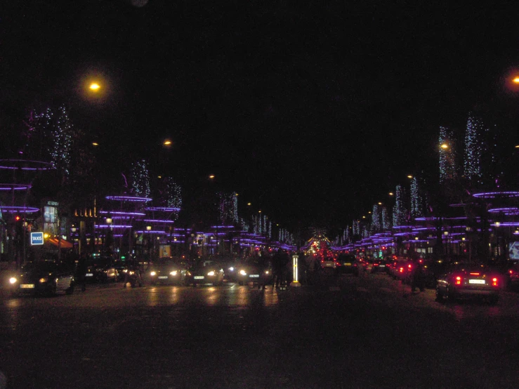 a city street filled with lots of traffic at night