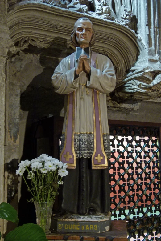 a statue of a priest takes a picture