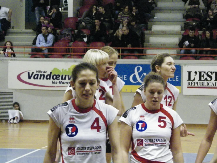 a group of young women standing on top of a basketball court