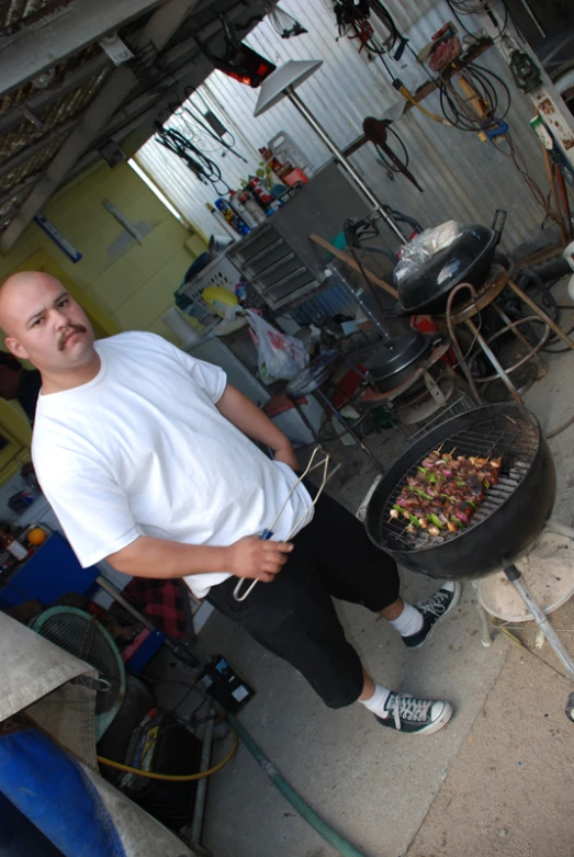 a man grilling some food on the back of a big truck