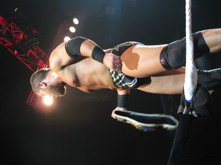 a man is holding up his knee in a wrestling ring