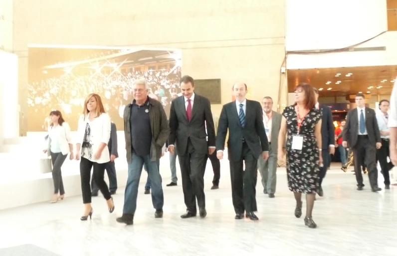 a group of business people are walking in an airport lobby