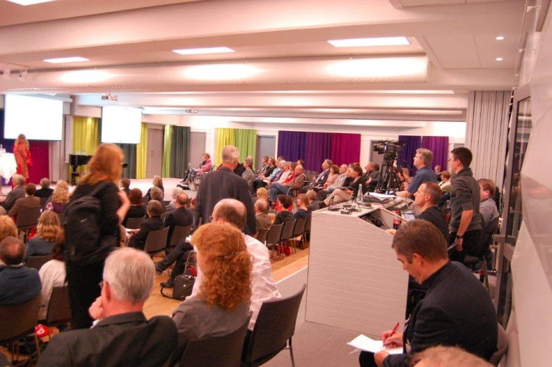 a crowd of people in a room at a business meeting