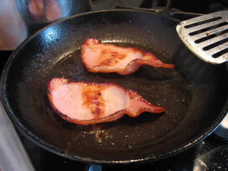 two pieces of cooked meat in a frying pan