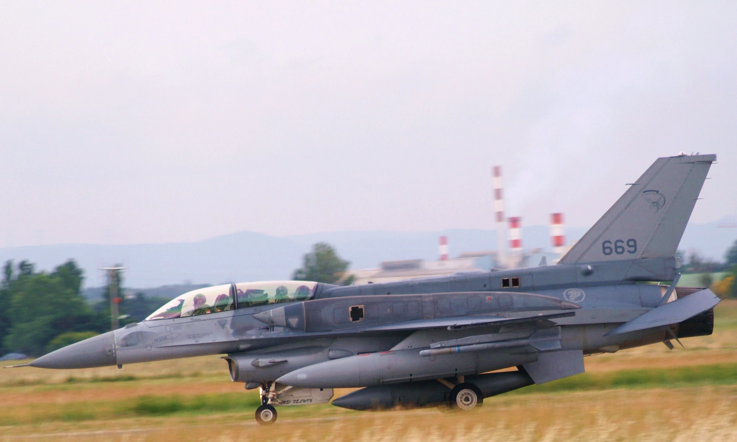 a fighter jet sitting on top of a field of grass