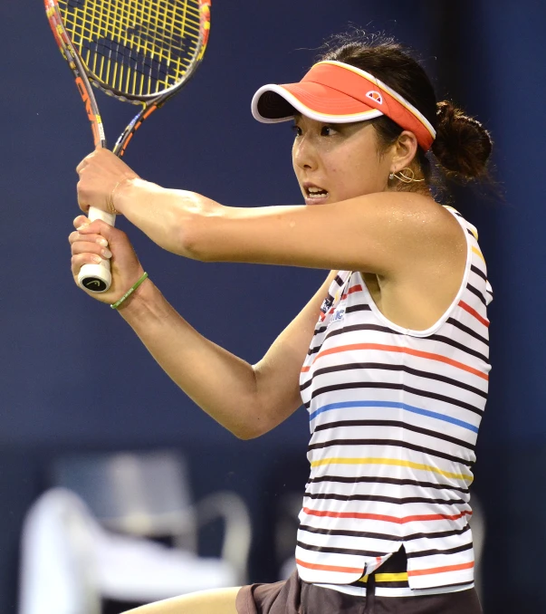 a woman with her hands behind her back and a racket