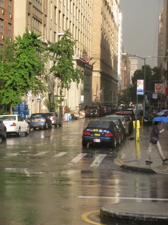 a man crossing a street while holding an umbrella