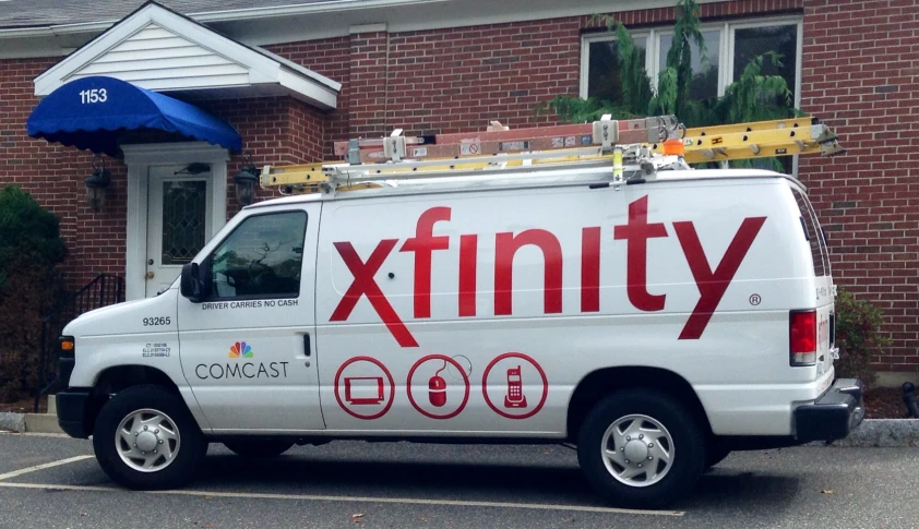 a white delivery truck parked in front of a brick building