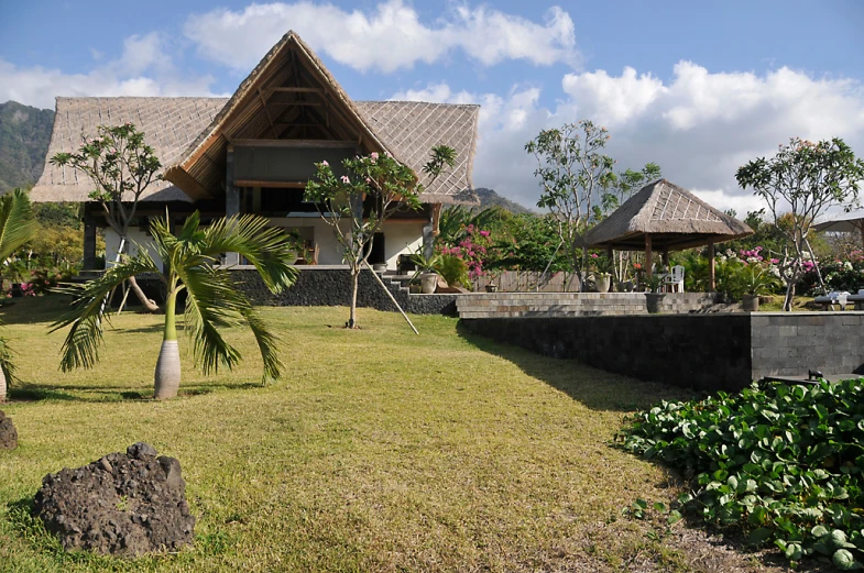 an exotic tropical home in the middle of green trees and flowers