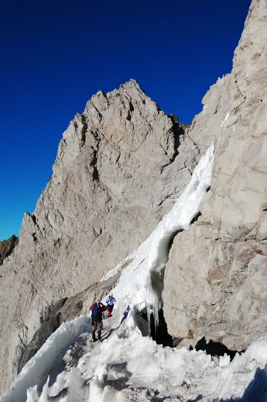 two mountain climbers hiking through deep snow