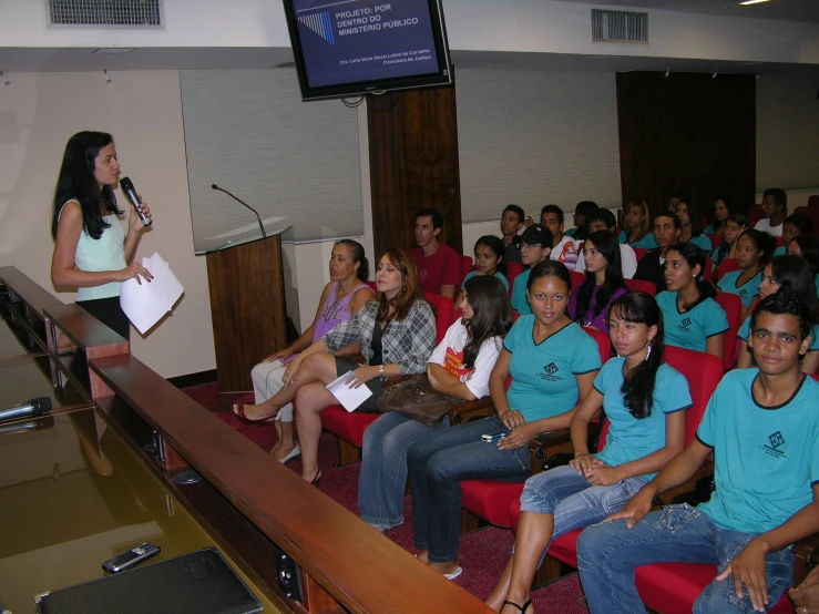 group of people sitting in a room with microphone