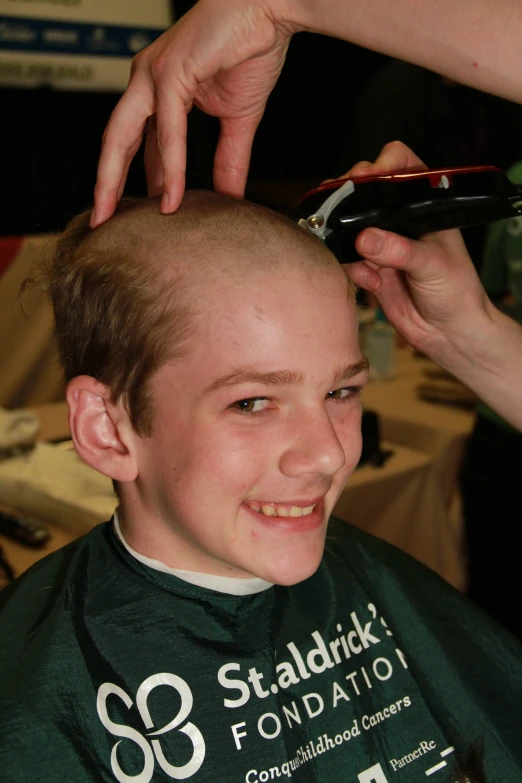 there is a young man getting his haircut