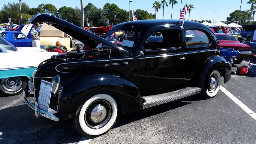 the antique black car is parked in the parking lot